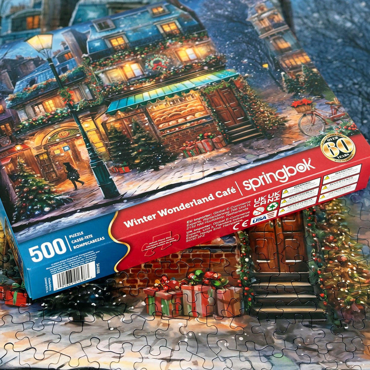 Springbok's Winter Wonderland Cafe 500 Piece Jigsaw Puzzle is a Picturesque Holiday Scene of a Cosy Cafe in The City