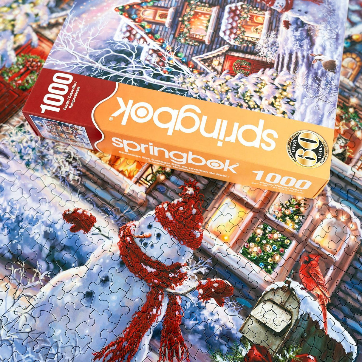 Springbok's Christmas Eve Cottage 1000 Piece Jigsaw Puzzle is a Classic Image of a Cozy Christmas Cottage Complete with Snowman and Santa Sailing Above in His Sleigh